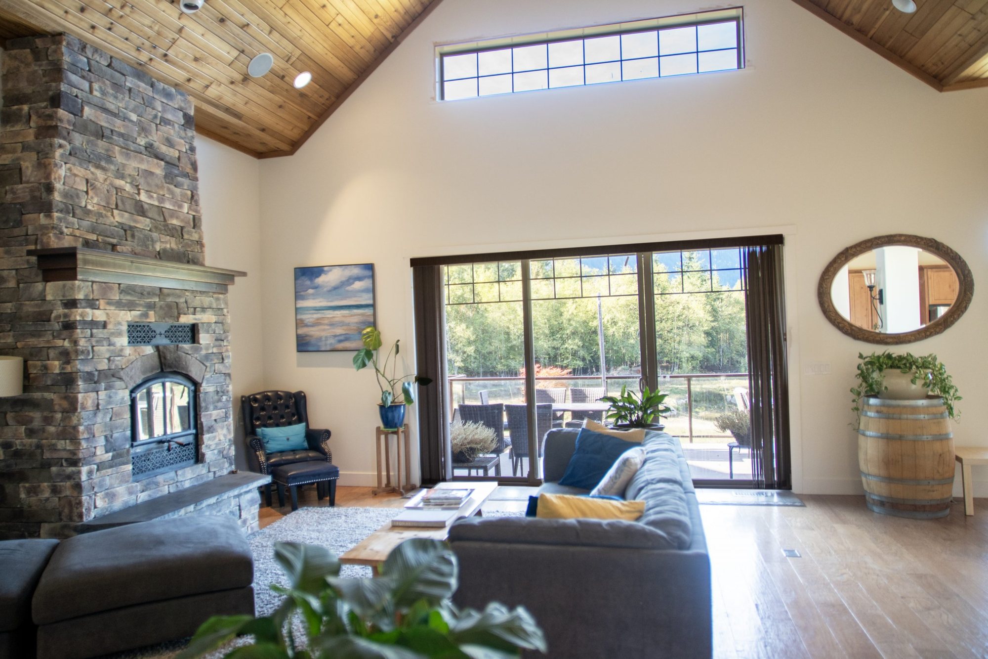 Great room with stone fireplace and mountain-facing windows at Santé Wellness Retreat